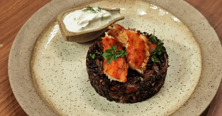 Foto da receita de King crab com arroz negro mar e terra