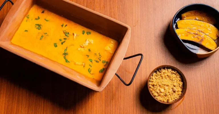 Foto da receita de Pintado no caldo de moqueca com banana grelhada e farofa de castanhas, coco e cumaru